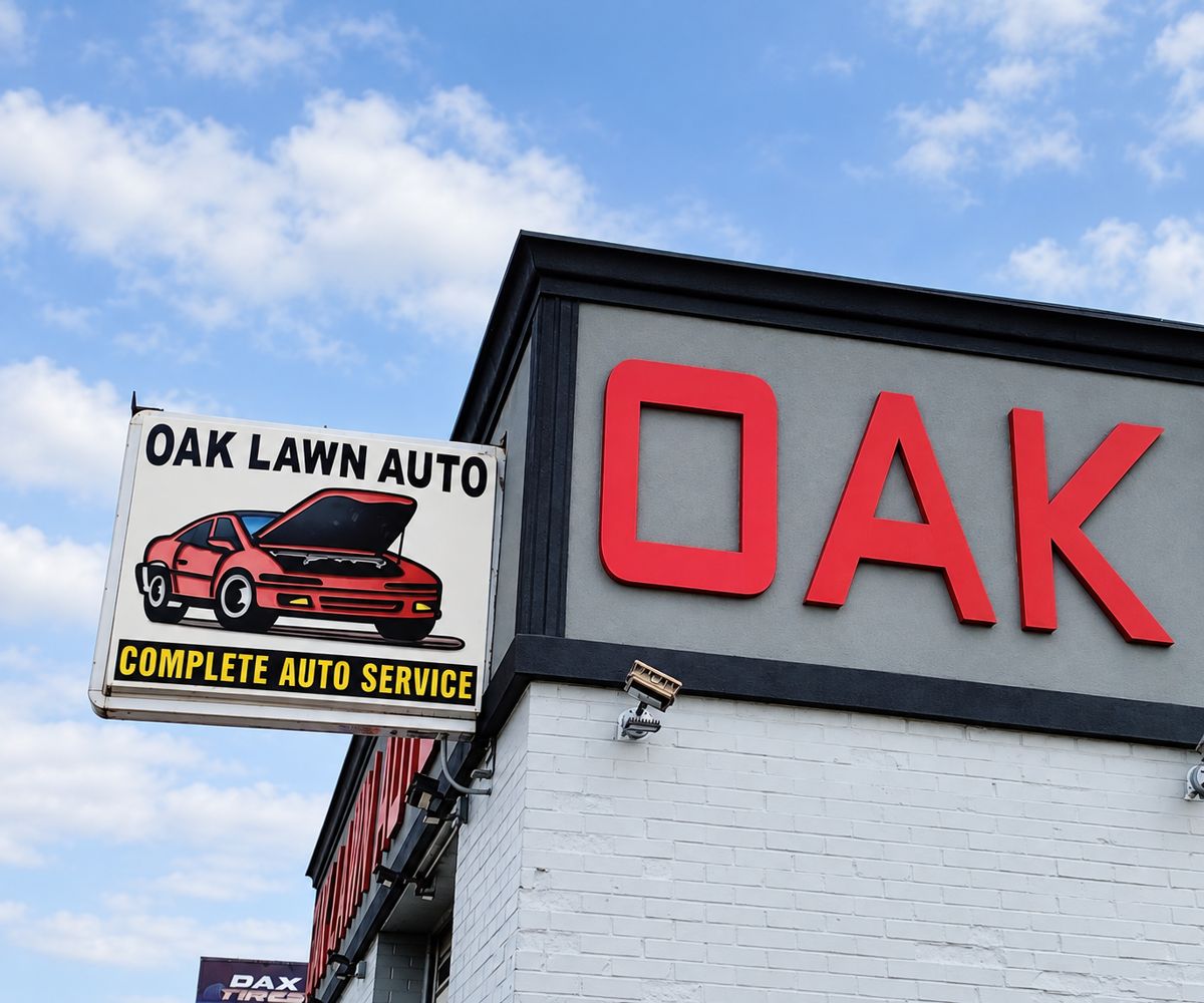 Oak Lawn Auto hanging sign next to the red OAK building letters